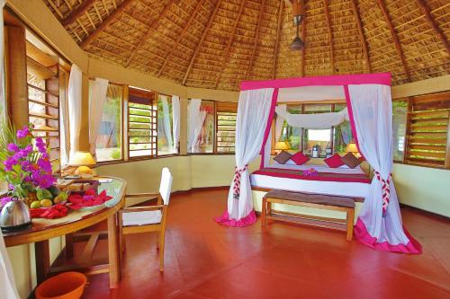 a bedroom with a bed with a table and a tableablish at Nosy Saba Private Island & Spa in Nosy Saba