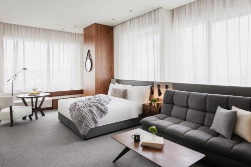 a bedroom with a bed and a couch at EPISODE Hsinchu, JdV by Hyatt Hotel in Hsinchu City