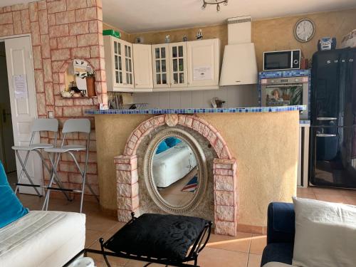 - un salon avec une cheminée et un miroir dans l'établissement Jardin D'Azur proche mer, à Cagnes-sur-Mer