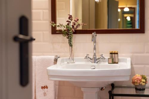 lavabo blanco en el baño con espejo en Bremon Boutique Hotel by Duquessa Hotel Collection, en Cardona