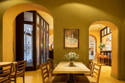 a dining room with a table with flowers on it at Bremon Boutique Hotel by Duquessa Hotel Collection in Cardona