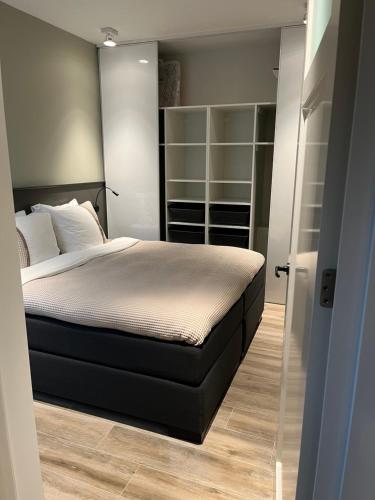 a bedroom with a large bed and a closet at B&B In de Schulp, retreat into your shell in Amstelveen