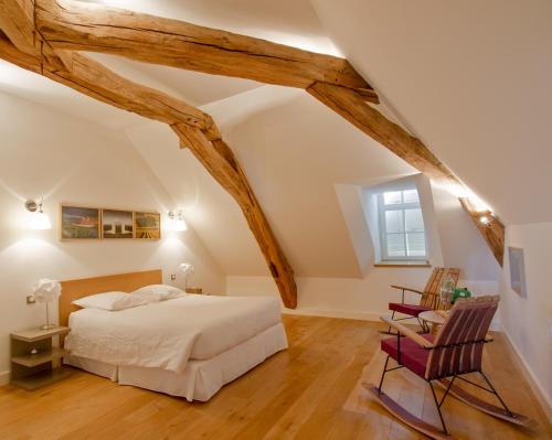 a bedroom with a bed and a chair at Chambres d'hôtes Le Clos des Tilleuls in Demigny