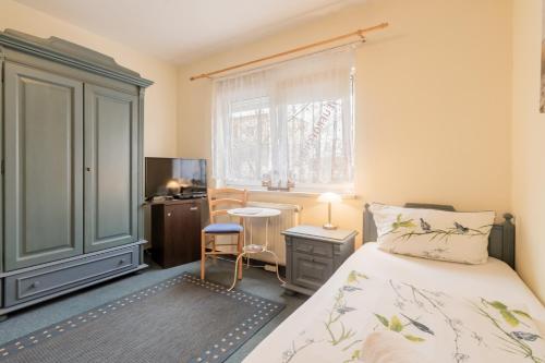 a bedroom with a bed and a desk and a window at Hotel Dori´s 108 in Berlin