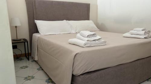 1 dormitorio con 1 cama con toallas en Gatto Bianco le Dimore, en Bari