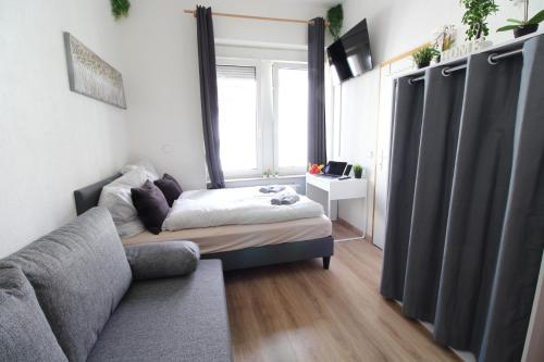 a living room with a bed and a couch at Downtown Apartments Ulm - im Herzen von Ulm & komfortable Boxspringbetten in Ulm