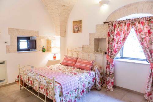 een slaapkamer met een bed en een raam bij Agriturismo Arco di Sole in Alberobello