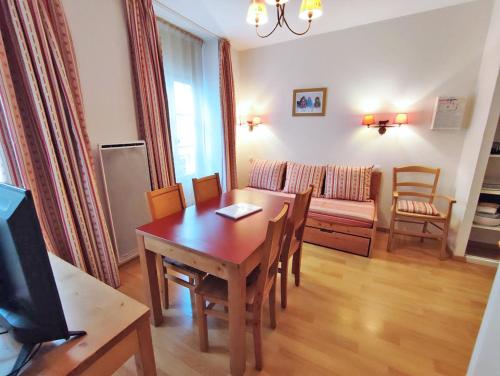 un salon avec une table et un canapé dans l'établissement Oo, T2, centre Luchon, wifi, casier à skis, ascenseur, 4 personnes, à Luchon