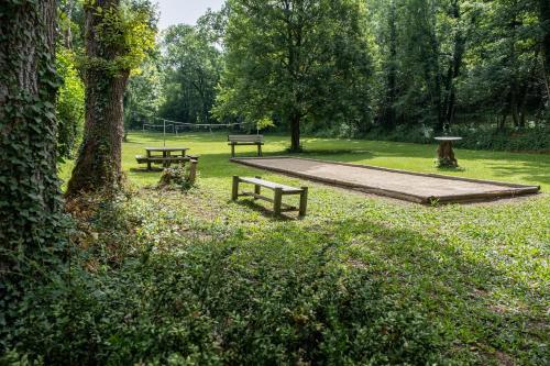 two picnic tables and benches in a park at La Grange du Héron in Balaguier-dʼOlt
