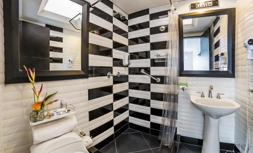 a bathroom with a black and white striped wall at Hotel Classic in Bogotá