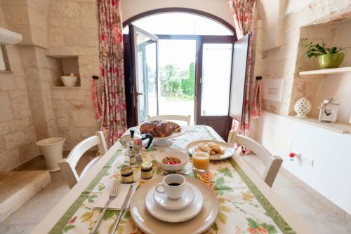 a dining room with a table with food on it at Agriturismo Arco di Sole in Alberobello