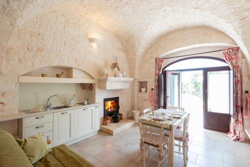 a kitchen with a living room with a fireplace at Agriturismo Arco di Sole in Alberobello