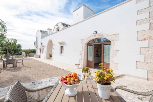 a table with a bowl of fruit on a patio at Agriturismo Arco di Sole in Alberobello