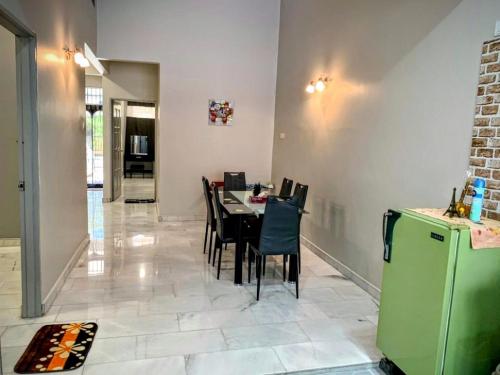 a dining room with a table and chairs and a refrigerator at AK Homestay in Port Dickson