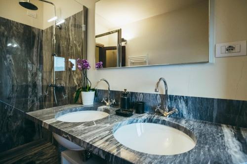 a bathroom with two sinks and a large mirror at Casa Vacanza La Pozza in Molazzana