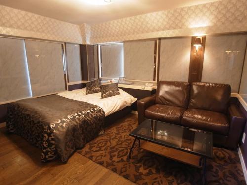 a hotel room with a bed and a couch at SKYROAD Adult Only in Tokyo