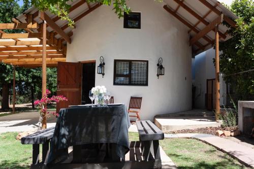 a patio with a table and chairs in front of a house at Rooikraal Farm Rondawel in Prince Alfreds Hamlet