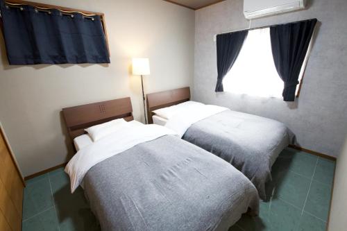 宮古島にあるVILLA CORALLIUM -MIYAKO-の窓付きの小さな部屋のベッド2台