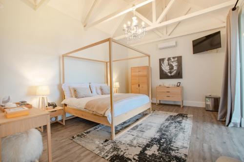a bedroom with a canopy bed and a tv at Essenwood House in Durban
