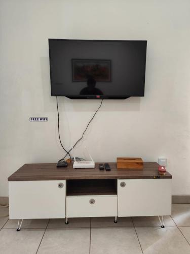 a flat screen tv hanging on a wall at Adiputra Guesthouse 2 by HomiQ in Ngabean