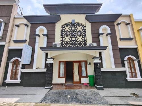 a house with a black and white at Adiputra Guesthouse 2 by HomiQ in Ngabean