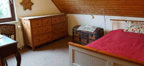 a small bedroom with a red bed and a dresser at Blaues Haus-Urlaub mit Alpakas oder nur eine schöne Unterkunft in der schaalseergion 