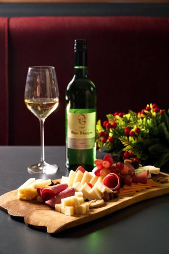 a bottle of wine and a plate of cheese and a glass at Radisson Blu Hotel, Cairo Heliopolis in Cairo