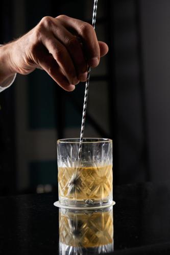 a person is stirring a drink in a glass at Radisson Blu Hotel, Cairo Heliopolis in Cairo