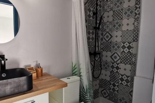 une salle de bain avec un lavabo et un rideau de douche dans l'établissement Cannes Pointe Croisette studio plage 2 min à Pieds, à Cannes