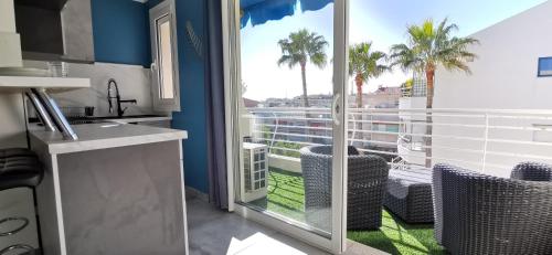- une cuisine avec vue sur un balcon avec des palmiers dans l'établissement Cannes Pointe Croisette studio plage 2 min à Pieds, à Cannes