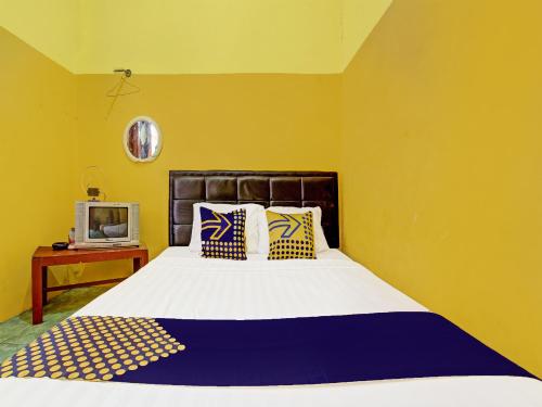een slaapkamer met een bed en een tv op een tafel bij OYO Life 2546 Griya Widya Syariah in Klaten