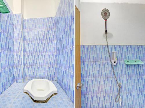 een blauwe betegelde badkamer met een toilet en een douche bij OYO Life 2546 Griya Widya Syariah in Klaten