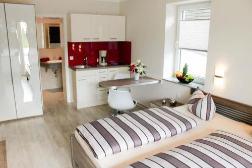 a bedroom with a large bed and a kitchen at Haus Feriendomizil in Ahlbeck