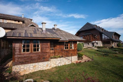 a large wooden house with a stone at ETNO SELO VRANEŠA Zlatar in Nova Varoš