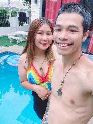 a man and a woman standing next to a pool at Sweet Party Hua-Hin Private Poolvilla From beach 3km in Hua Hin