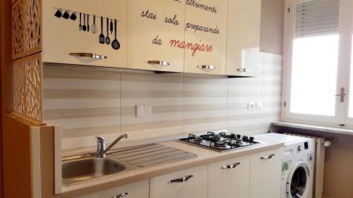una cocina con fregadero y estufa horno superior en SOPHIE HOME Torino, Nuovissima vicino Juventus Stadium, en Turín