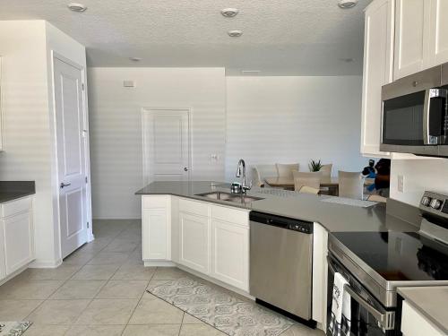 a kitchen with a sink and a counter top at Grand Family Deluxe 4BR House near Disney Parks in Davenport