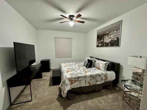 1 dormitorio con 1 cama y ventilador de techo en Grand Family Deluxe 4BR House near Disney Parks, en Davenport