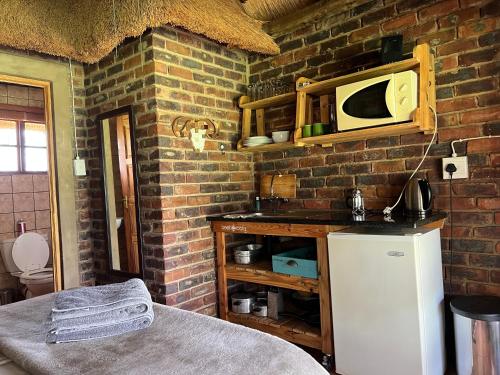a kitchen with a microwave on a brick wall at Vilagama Game Lodge in Naboomspruit