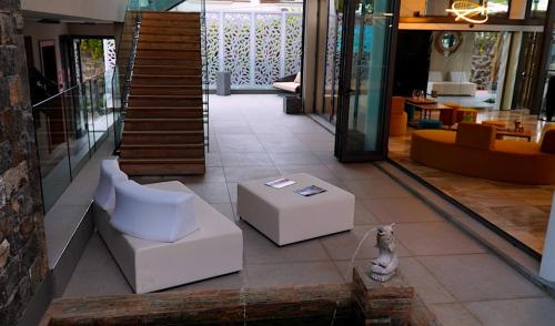 a living room with white furniture and a staircase at Wonders Beach Boutique Hotel in Mont Choisy