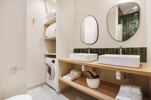 une salle de bain avec deux lavabos et une machine à laver dans l'établissement Pick A Flat's Apartment near place de la Bastille - Rue du Faubourg Saint Antoine, à Paris