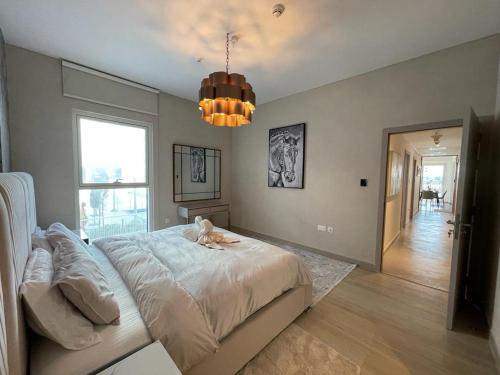 Un dormitorio con una cama grande y una lámpara de araña. en Smart Living Apartment en Abu Dabi