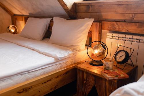 a bedroom with a bed and a clock on a table at ETNO SELO VRANEŠA Zlatar in Nova Varoš