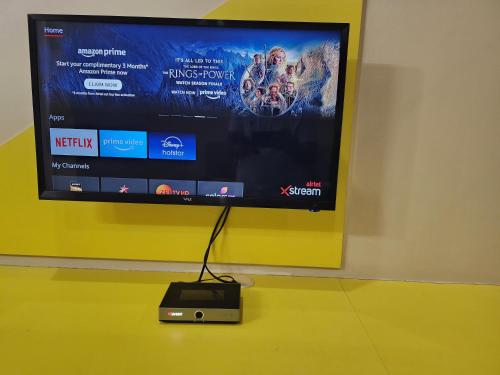 a television is hanging on a wall with a speaker at The Cocoon in Gonikoppal