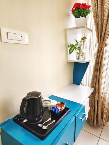 a blue cabinet with a tea kettle on it at The Cocoon in Gonikoppal