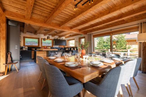 une salle à manger avec une longue table en bois et des chaises dans l'établissement CHALET LA MANIGODINE Piscine 18-24 pers, à Manigod