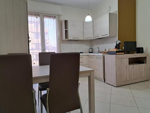 a kitchen with a table and chairs and a kitchen with white cabinets at Navili Grand Apartment in Trezzano sul Naviglio