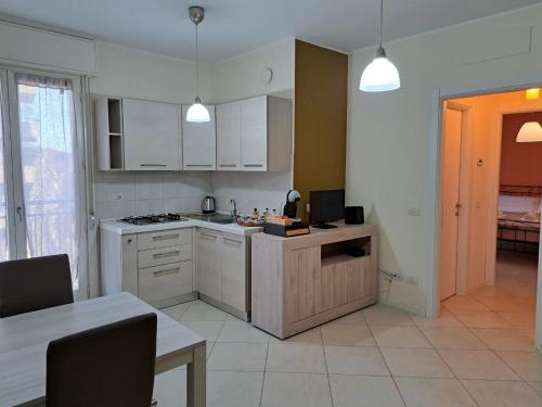 una cocina con armarios blancos y una mesa con comedor. en Navili Grand Apartment en Trezzano sul Naviglio