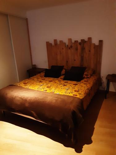 Un dormitorio con una cama grande con cabecero de madera. en La petite Cabrière, en Cazouls-lès-Béziers