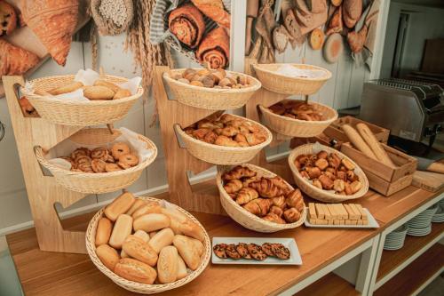 una tavola ricoperta di cesti di diversi tipi di pane di Apartamentos Playa Moreia a S'Illot